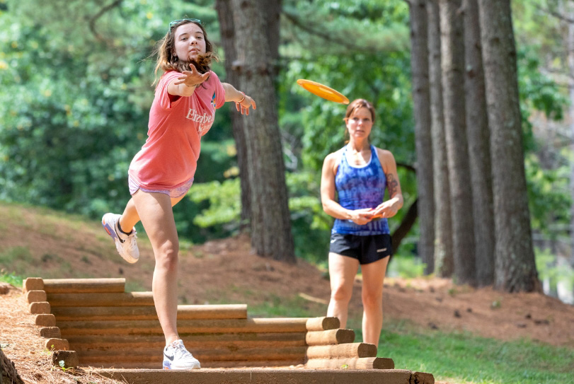 2 women playing disc golf